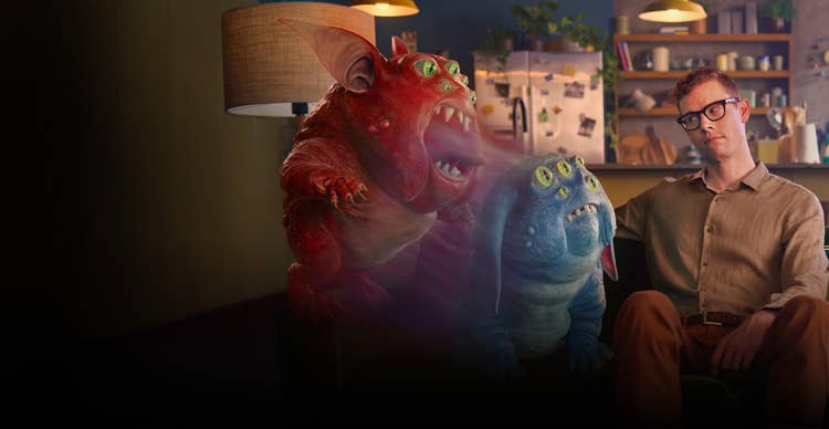 Creature and man sitting next to one another on a couch